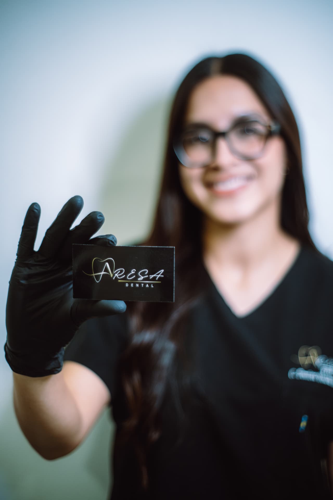 Especialista de Aresa Dental mostrando tarjeta de la clínica